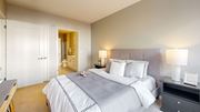 Minnetonka apartment for rent - A bedroom with a large bed and a nightstand with a lamp.
