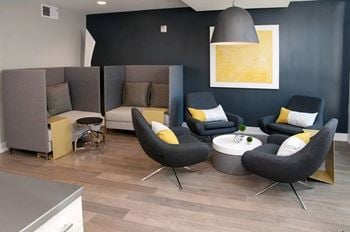 Cozy clubroom with indoor fireplace, coffee bar, and workspace.
