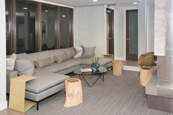 Cozy clubroom with indoor fireplace, coffee bar, and workspace.