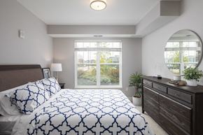 Lakeville apartment for rent - A bedroom with a large bed and a mirror on the wall.at The Edison at Avonlea, Lakeville, MN 55044