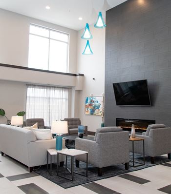 A living room with a grey couch, a fireplace, and a television.