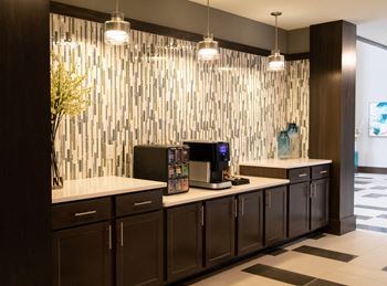 A modern kitchen with dark wood cabinets and a white countertop.