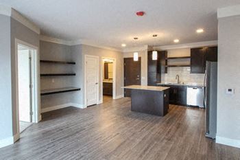 A kitchen with a refrigerator, sink, and cabinets is shown.