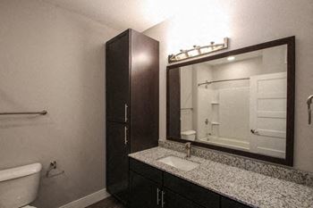 A bathroom with a white tub, sink, and mirror.