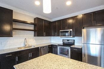 A kitchen with black cabinets and stainless steel appliances.