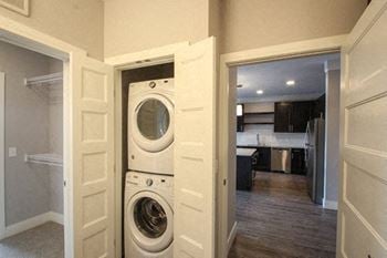 A washer and dryer are stacked in a small laundry room.
