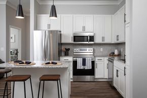Maple Grove apartment for rent - A modern kitchen with white cabinets and a stainless steel refrigerator.at The Edison at Maple Grove, Maple Grove, 55311