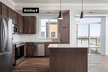 A kitchen with dark wood cabinets and a large island.