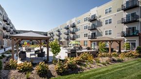 Shoreview apartment for rent - A sunny day at a residential complex with a gazebo and landscaped gardens at The Edison at Rice Creek I and II, Shoreview, MN .