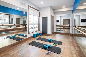A yoga studio with mats and blocks on the floor.