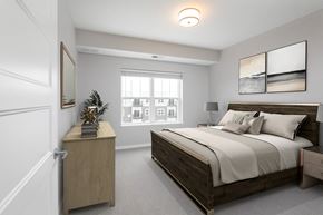 Woodbury apartment for rent - A bedroom with a large bed and a wooden nightstand at The Edison at Woodbury, Woodbury Minnesota