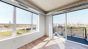 A room with a large window overlooking a cityscape.