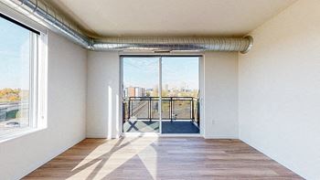 A room with a view of a balcony through a sliding glass door.