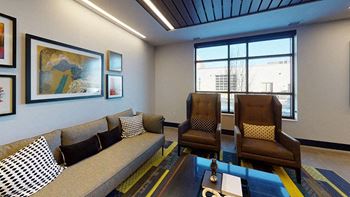 A living room with a grey couch, two brown chairs, and a coffee table.