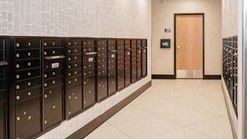 A hallway with a row of mailboxes on the wall.