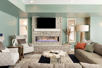A living room with a fireplace and a flat screen tv mounted above it.