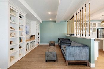 A living room with a blue couch and a white bookshelf.
