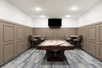 A room with a pool table and chairs.