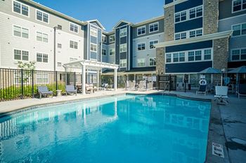 A large swimming pool in front of apartment buildings.