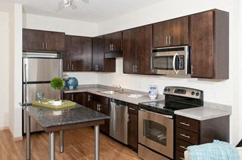 A kitchen with a stainless steel refrigerator, microwave, oven, and dishwasher.