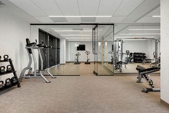 A spacious gym with a variety of equipment including treadmills, weights, and exercise machines.