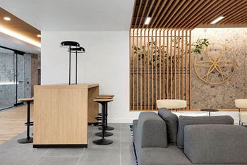 A reception area with a wooden counter and grey couches.