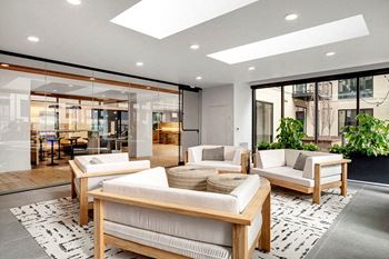 A modern living room with a glass wall and a skylight.
