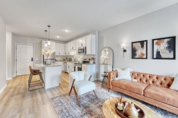 White Bear Lake apartment for rent - A modern living room with a brown leather couch and a wooden coffee table.