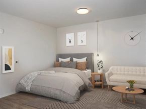 Minneapolis apartment for rent - A bedroom with a large bed and a white couch at The Redwell Apartments, Minnesota