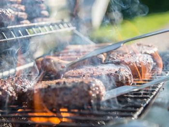 Hot dogs are being grilled on a barbecue