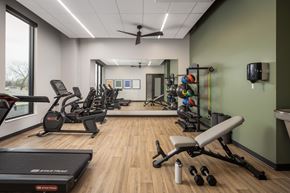 Bloomington apartment for rent - A gym with a treadmill, weights, and exercise equipment.
