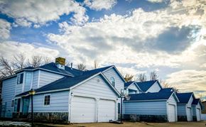 Logan townhouse for rent - a group of white houses with a cloudy sky in the background