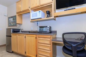 San Jose apartment for rent - A kitchen with wooden cabinets and a black chair.