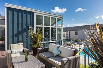 A patio with furniture and a pool in front of a house