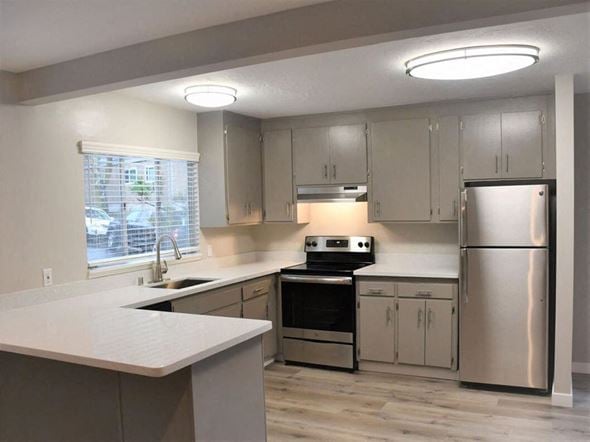 Mill Valley apartment for rent - a kitchen with stainless steel appliances and white counter tops at Trailhead Apartments at Tam Junction, California, 94941
