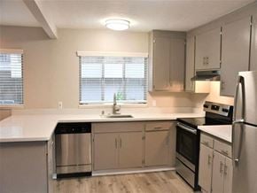 Mill Valley apartment for rent - an empty kitchen with white counter tops and stainless steel appliances at Trailhead Apartments at Tam Junction, Mill Valley, CA
