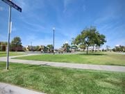 Oxnard apartment for rent - a park with a playground and a street sign at The Vines at Riverpark, LLC, California