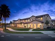 Oxnard apartment for rent - a large building with a palm tree in front of it at The Vines at Riverpark, LLC, Oxnard, CA
