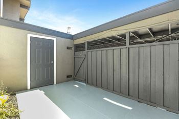 A garage with a gray door and a gray fence