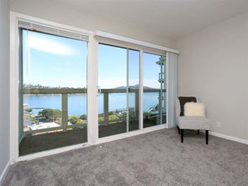 A living room with a view of a lake and a chair