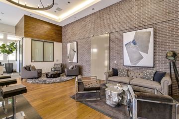 Redwood City apartment for rent - A modern living room with a grey couch and a large abstract painting on the wall.