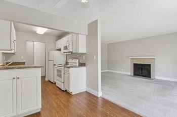A view of a kitchen and a living room with a fireplace