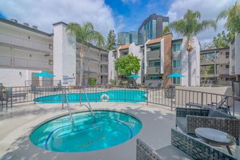 A swimming pool at a hotel with palm trees