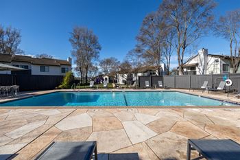 A swimming pool with a house in the background