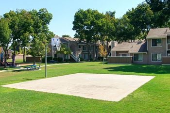 A basketball court in the middle of a grass field