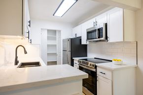 Santa Clara apartment for rent - A kitchen with white cabinets and black appliances at Summerwood Apartment , California, 95050