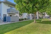 Tarzana apartment for rent - an apartment building with a lawn and trees in front of it at BLVD Apartments LLC, Tarzana, CA