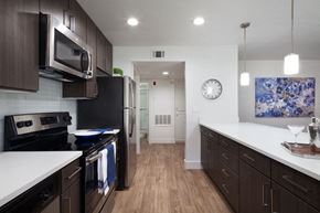 Yorba Linda apartment for rent - a kitchen with white counter tops and black appliances at The Bryant, Yorba Linda, CA 92887