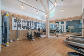 Napa apartment for rent - a gym with cardio machines and weights on a wooden floor at Napa Green Apartments LLC, Napa, CA 94559