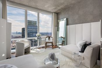 A modern bedroom with a large window overlooking the city.